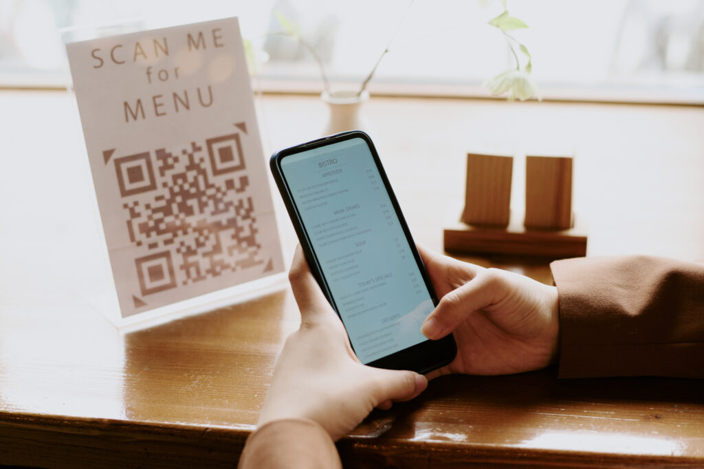 Menu digitale ristorante tramite QR code su smartphone, con lista piatti e prezzi